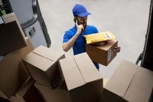 کارگر باربری کرج و حومه در حال هماهنگی بسته‌بندی کارتن‌های اثاثیه در کرج